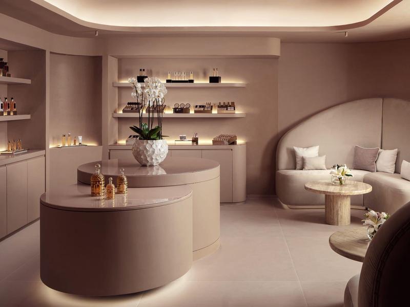 Elegantní moderní salonek s zakřiveným nábytkem a teplým osvětlením.