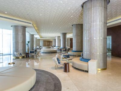 Großer heller Empfangsbereich mit runden Säulen, bequemen Sitzgelegenheiten und modernem Design.