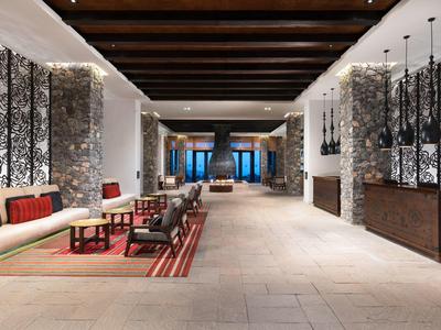 Bright hotel lobby with modern seating areas, artworks, and wooden beam ceiling