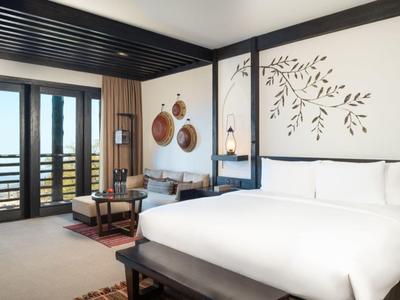 Modern hotel room with large bed, balcony, and Japanese-inspired decor.
