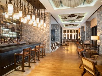 Elegante Hotelbar mit weitem Innenraum, Holzboden und warmem Licht.