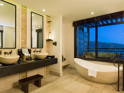 Modern bathroom with freestanding bathtub and double sinks with large mirrors.