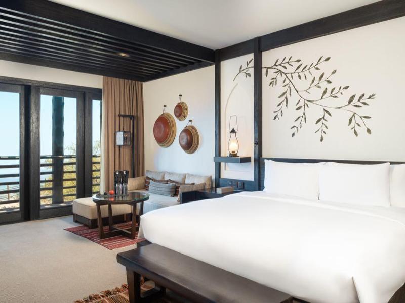 Modern hotel room with large bed, balcony, and Japanese-inspired decor.