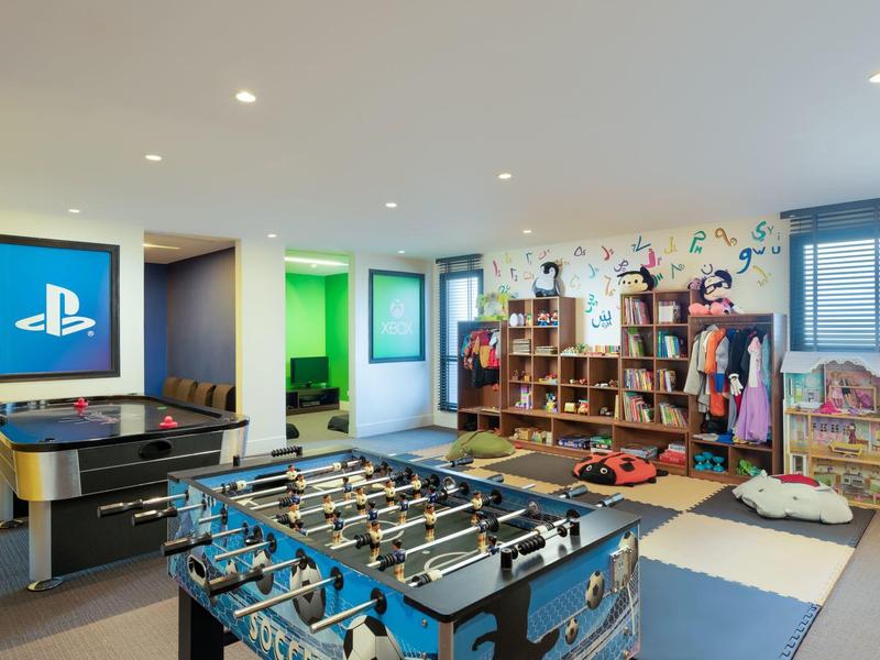 Game room with foosball, arcade game, and bookshelf area in a bright room