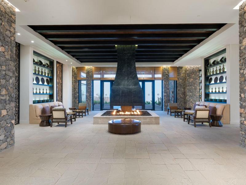 Modern lounge area with central fireplace and stone walls in a hotel