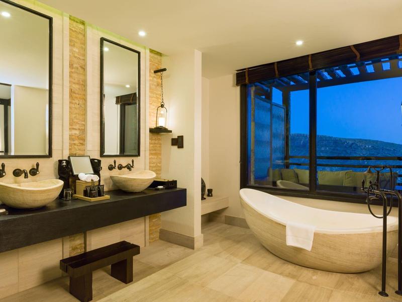 Modern bathroom with freestanding bathtub and double sinks with large mirrors.
