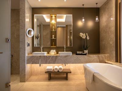 Elegant badkamer met bad, wastafels en stijlvolle verlichting.