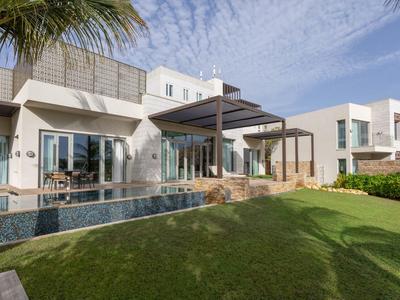 Villa vacanze moderna con grande piscina e prato ben curato sotto un cielo limpido.