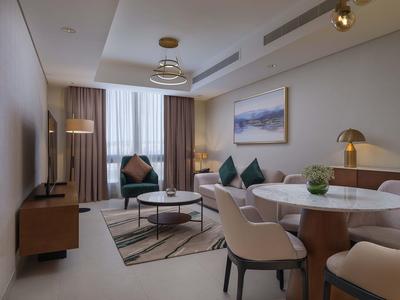 Modern living room with sofa, coffee table, and dining area with chairs.