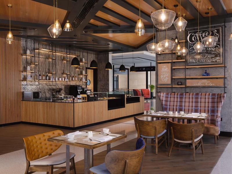 Modern café with wooden furniture and stylish hanging lights.