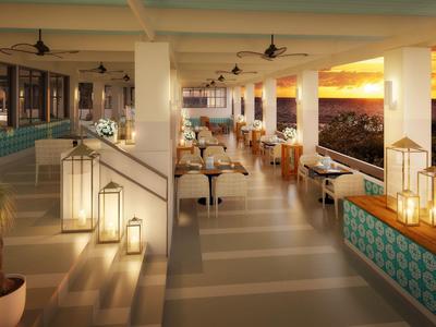 Elegante Hotelbar mit Innen- und Außenbereich, beleuchtet bei Sonnenuntergang.