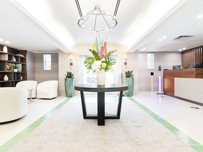 Heller Hotellobby mit floraler Mitteldekoration und modernen Sitzbereichen.