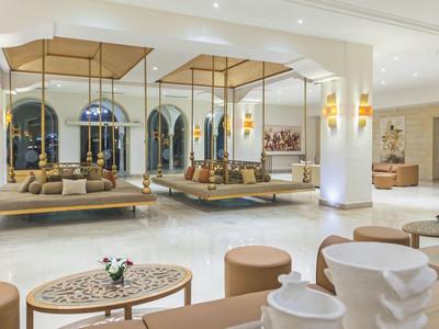 Jasny, nowoczesny hol hotelowy z wygodnymi miejscami do siedzenia i dużymi oknami.