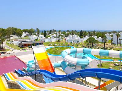 Bunte Wasserrutschen in verschiedenen Formen und Größen in einem Freizeitpark unter blauem Himmel.