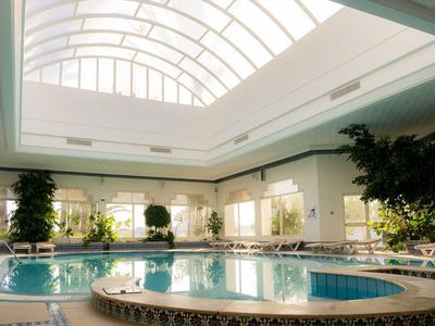 Innenpool mit natürlichem Licht durch großes Gewölbefenster im Hotel