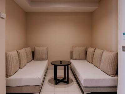 Petit espace salon avec deux canapés et une table ronde noire dans un coin confortable.