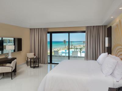 Chambre d'hôtel moderne avec balcon et vue sur la mer.