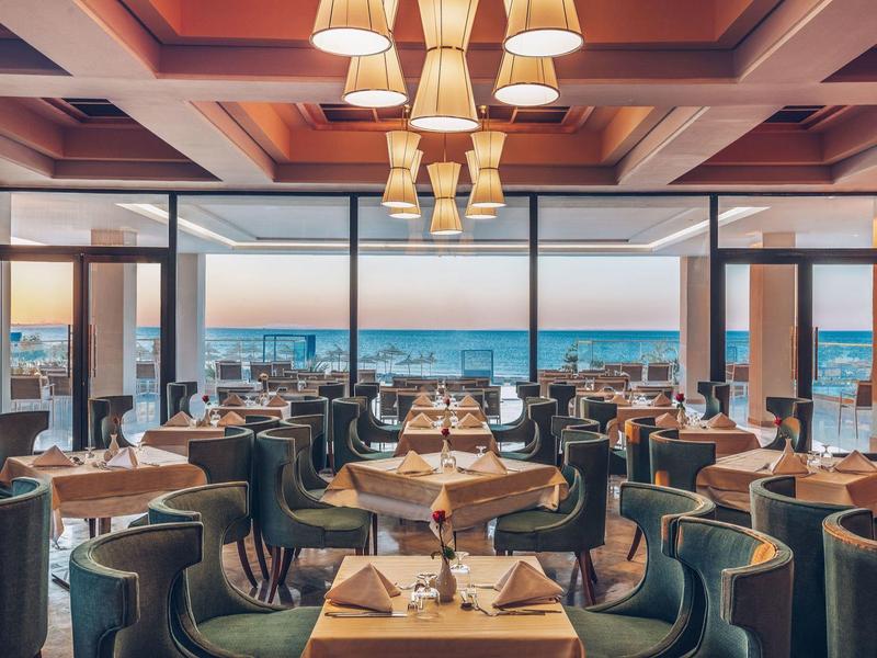 Restaurant élégant avec vue sur la mer et tables et chaises aménagées avec style.