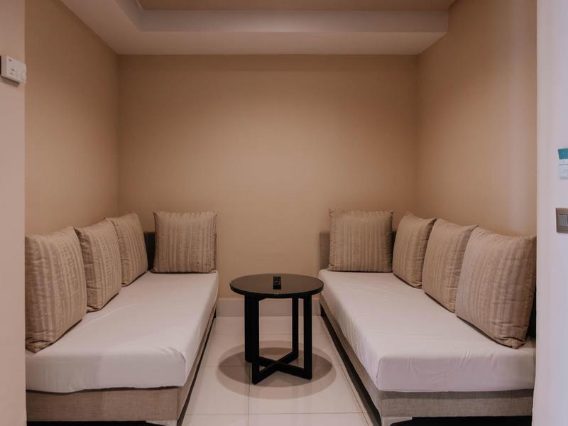 Petit espace salon avec deux canapés et une table ronde noire dans un coin confortable.