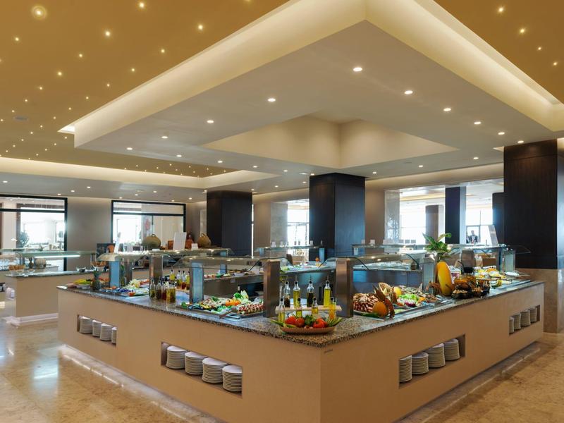 Buffet d'hôtel moderne avec diverses nourritures et éclairage lumineux.