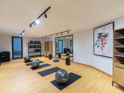 Moderner Fitnessraum mit Yogamatten, Gymnastikbällen und gestalteter Wandkunst.