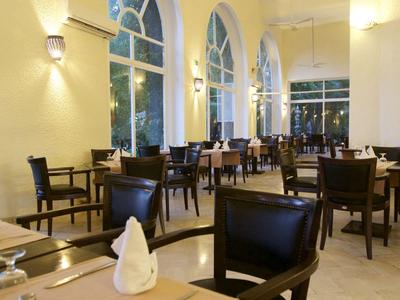 Helles, stilvolles Restaurant mit dunklen Holzstühlen und großen Rundbogenfenstern.