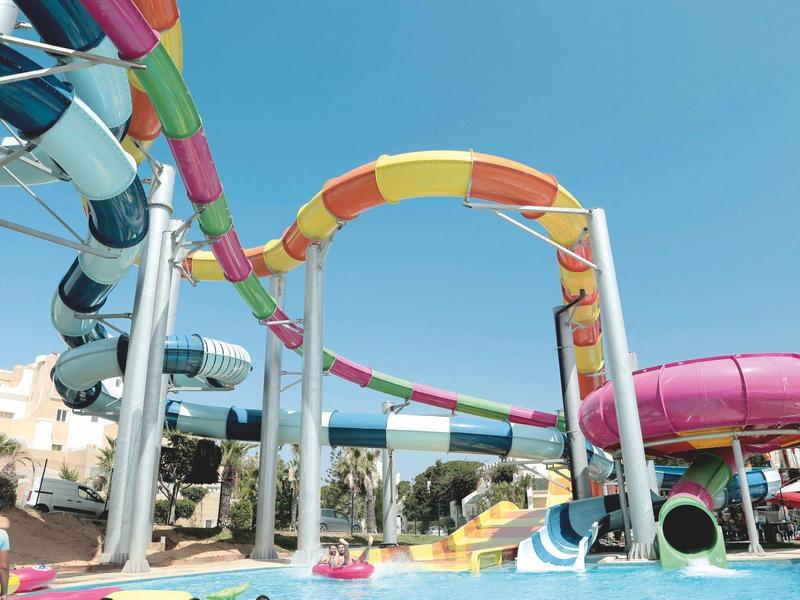 Bunte Wasserrutschen steigen über einem Pool in einem Wasserpark empor.