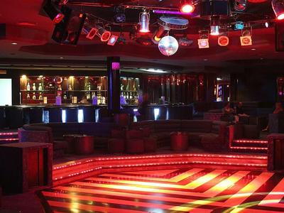 Leerer Tanzboden mit bunten Lichtern und reflektierenden Wänden in einem Club.