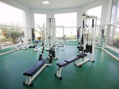 Sala fitness con attrezzature per allenamento con i pesi e grandi finestre con vista esterna.