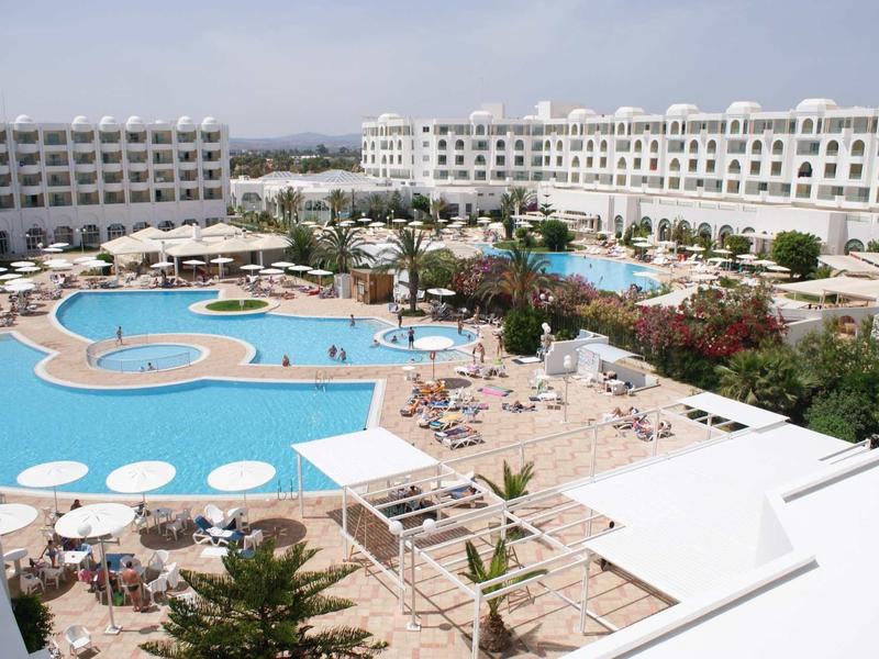 Grande hotel con più piscine e lettini in un resort