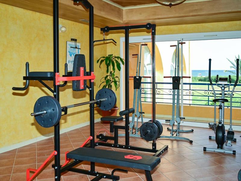 Gimnasio moderno con equipos y una gran ventana con vista al exterior.