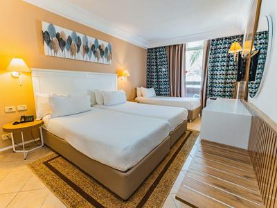 Modernes Hotelzimmer mit zwei großen Betten, elegantem Dekor und komfortabler Beleuchtung.