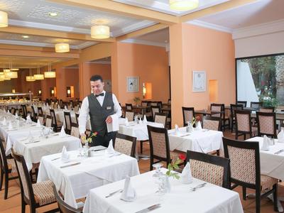 Ein elegantes Restaurant mit gedeckten Tischen und einem Kellner im Anzug.