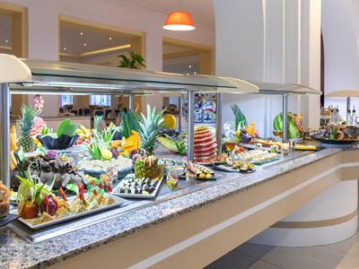 Bufet z różnorodnym wyborem świeżych owoców i dań w hotelowej restauracji.