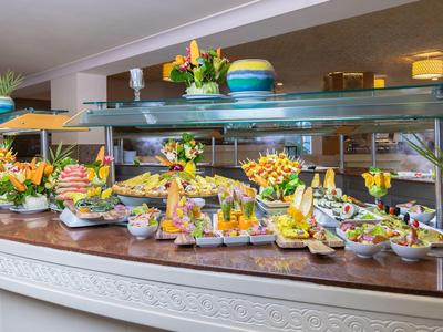 Buffet mit vielfältigen Vorspeisen, frischem Gemüse, Obst und farbenfrohen Arrangements.