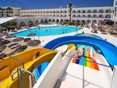 Vodní park s barevnými skluzavkami a velkým bazénem na hotelovém nádvoří.