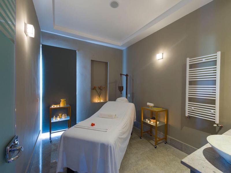 Sala trattamento con lettino da massaggio, illuminazione accogliente e termoarredo porta asciugamani.