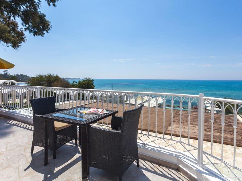 Terrasse avec table et chaises donnant sur la mer et le ciel bleu