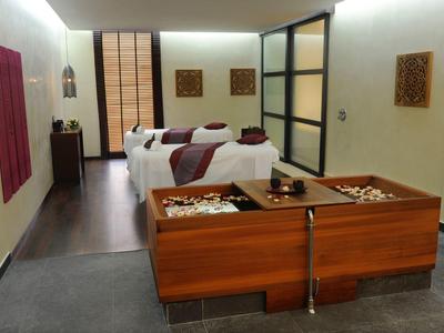 Modernes Spa mit zwei Fußbädern und zwei Liegen in hellem Raum.