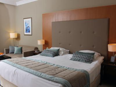 Modern eingerichtetes Hotelzimmer mit großem Doppelbett und weichen Kissen.