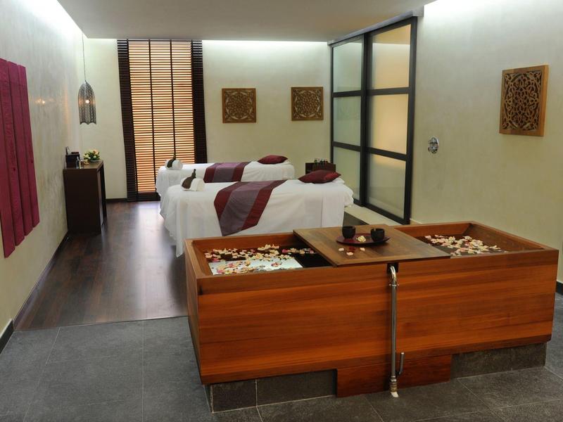 Modernes Spa mit zwei Fußbädern und zwei Liegen in hellem Raum.