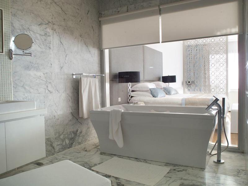 Modernes Badezimmer mit freistehender Badewanne und Marmorfliesen.