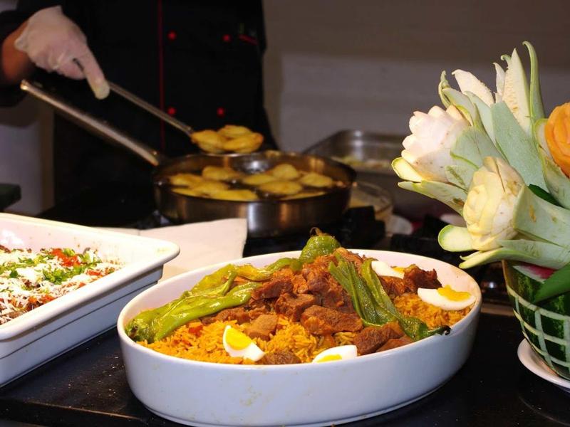 Bufet s různými pokrmy, včetně zapékací mísy a jídla s vejci a masem.