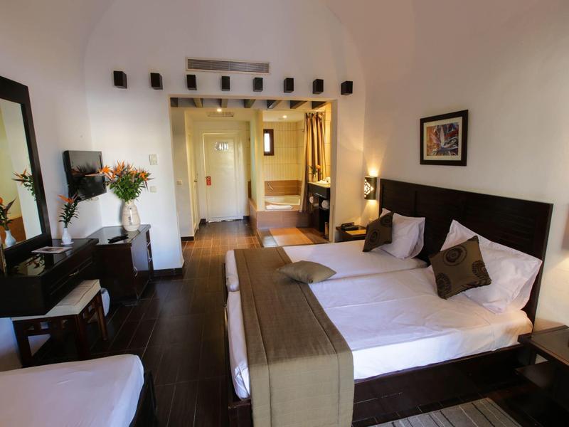 Helles Hotelzimmer mit Doppelbett, Schreibtisch, Stuhl und modernem Dekor.