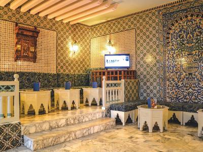 Tradiční místnost s dlaždicemi, lavicemi a televizí.