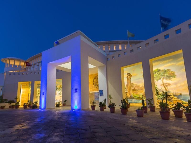 Budynek hotelu z oświetlonymi ścianami i dużymi oknami w nocy