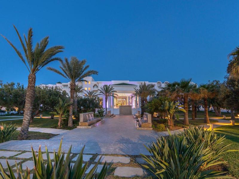 Elegancki hol wejściowy z palmami i wyraźną ścieżką o zachodzie słońca