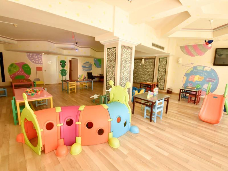 Světle dětský koutek s barevným housenkovým tunelem a skluzavkou na dřevěné podlaze.