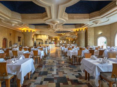 Velká elegantní jídelna s bílými ubrusy a dřevěnými židlemi v hotelu.