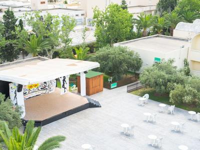 Palco all'aperto e area seduta in un giardino d'hotel verde.